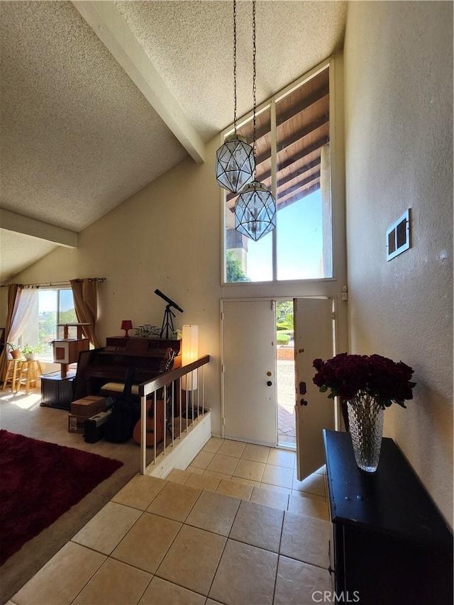 tiled foyer featuring a textured ceiling, high vaulted ceiling, a textured wall, and beam ceiling