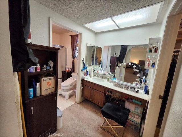 full bathroom with toilet, a textured ceiling, vanity, and a shower stall