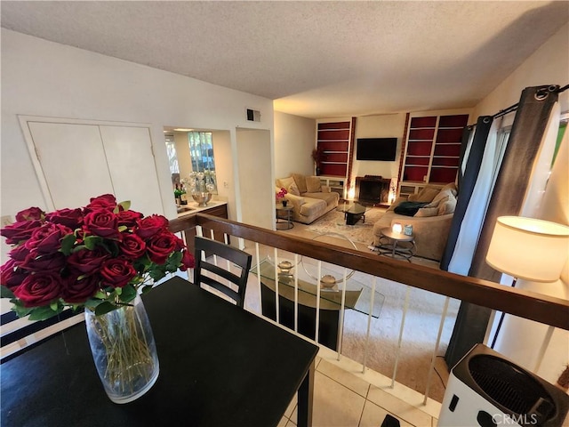 dining space with a textured ceiling, tile patterned flooring, and visible vents
