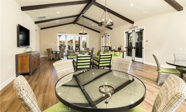 dining space with a wealth of natural light, wood finished floors, and lofted ceiling with beams