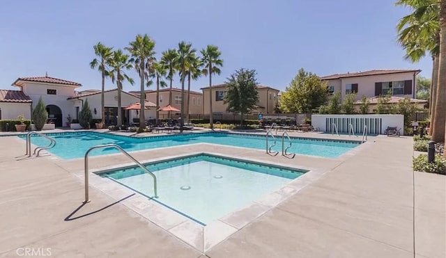 community pool with fence and a patio