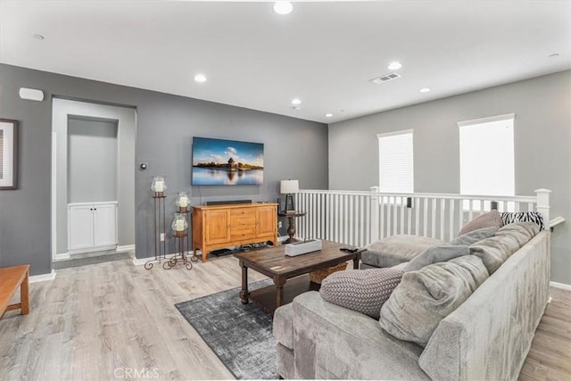 living area with light wood-type flooring, baseboards, visible vents, and recessed lighting