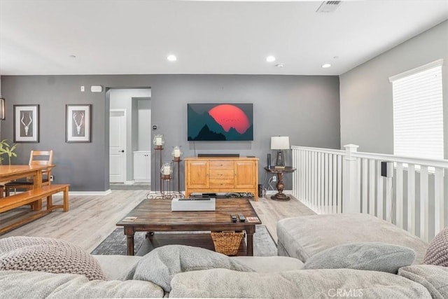 living area featuring light wood finished floors, baseboards, visible vents, and recessed lighting