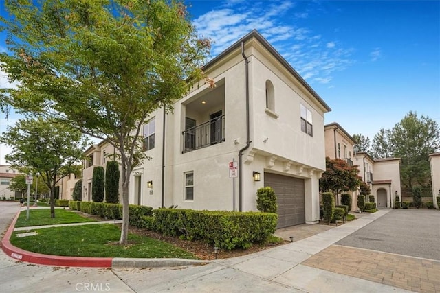 view of home's exterior featuring stucco siding, an attached garage, and driveway