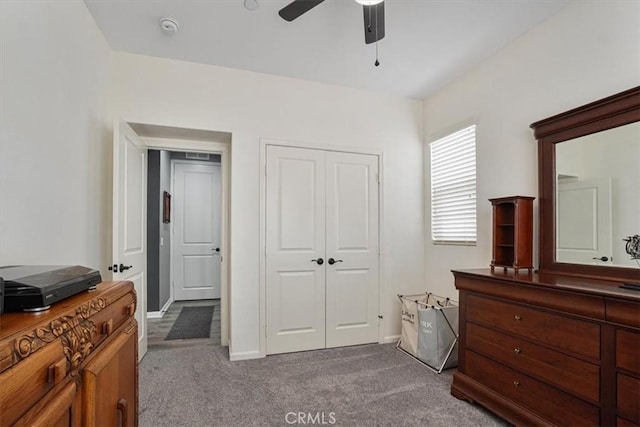 bedroom with dark carpet, baseboards, a ceiling fan, and a closet