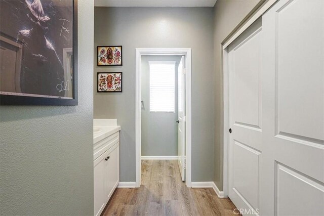 corridor with wood finished floors and baseboards