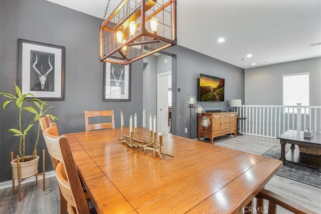 dining space with baseboards, wood finished floors, visible vents, and recessed lighting