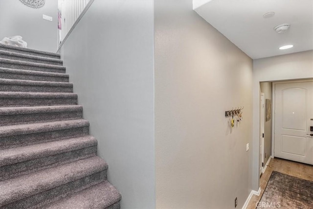 stairs featuring wood finished floors and baseboards