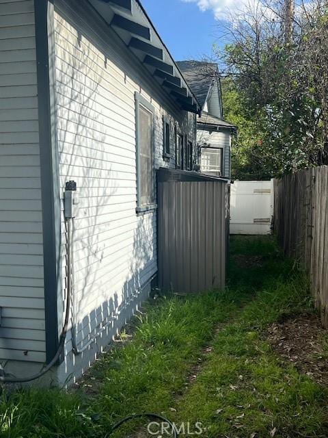 view of side of home featuring fence