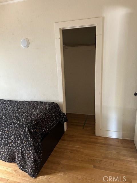 bedroom featuring baseboards and wood finished floors
