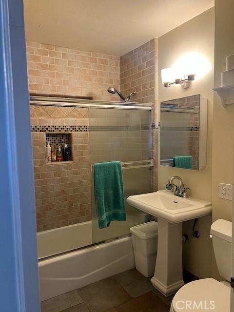 full bathroom with toilet, shower / bath combination with glass door, and tile patterned flooring