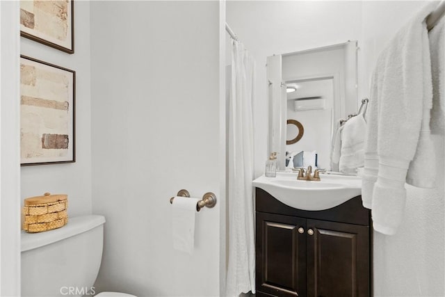 full bath with toilet, a wall unit AC, and vanity