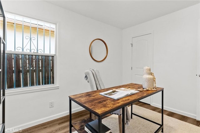 home office with baseboards and wood finished floors