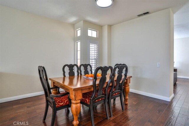 dining room featuring baseboards, dark wood finished floors, and visible vents
