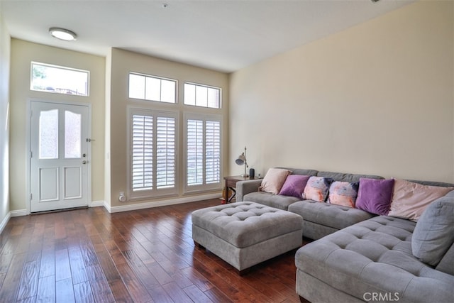 living area with baseboards and dark wood finished floors