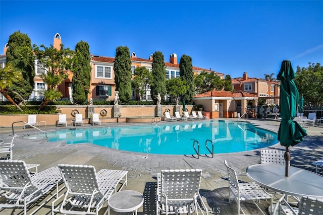 community pool featuring a patio and fence