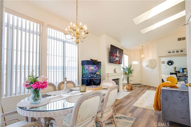 28751 Broadstone Way, Menifee, CA 92584 - dining area featuring healthy amount of natural light, a chandelier, wood finished floors, a skylight, and lofted ceiling