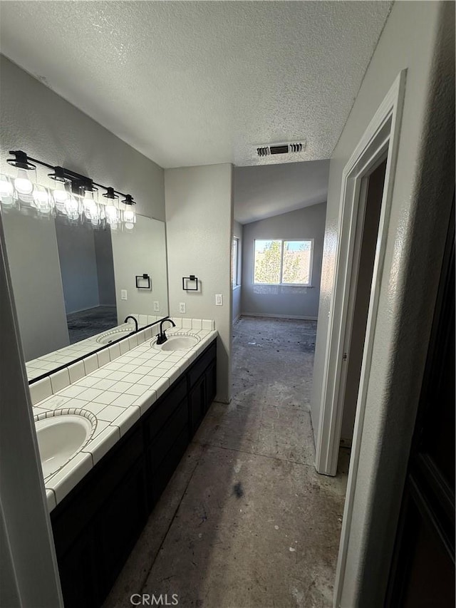 bathroom featuring visible vents, a sink, and a textured ceiling