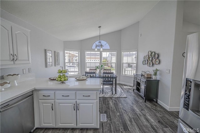 kitchen featuring stainless steel dishwasher, a peninsula, white cabinetry, and vaulted ceiling