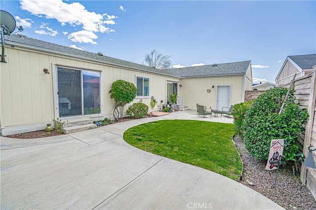 rear view of property with a patio area, entry steps, fence, and a lawn