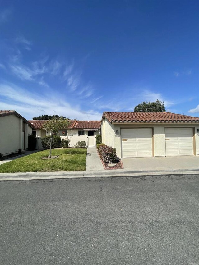 1726 Belle Meade Rd, Encinitas, CA 92024 - view of front facade featuring a tile roof, stucco siding, a front lawn, and driveway