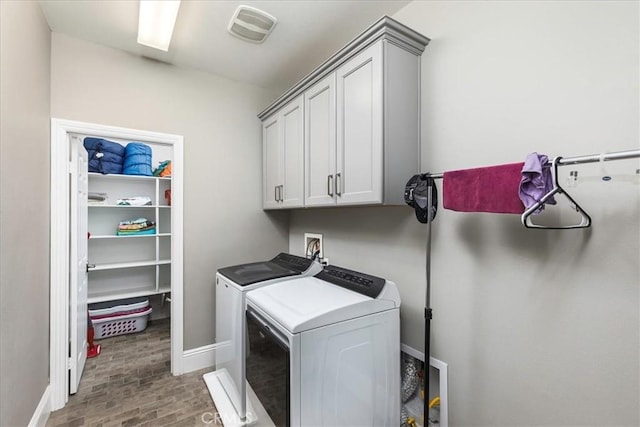30580 Hawkscrest Rd, Murrieta, CA 92563 - clothes washing area with visible vents, baseboards, washer and dryer, wood finished floors, and cabinet space