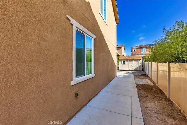 30580 Hawkscrest Rd, Murrieta, CA 92563 - view of side of property featuring a storage shed, an outbuilding, a fenced backyard, and stucco siding