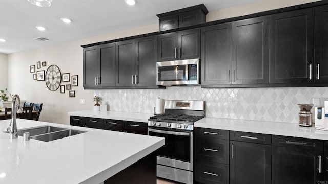 10861 Blake Way, San Diego, CA 92129 - kitchen with stainless steel appliances, dark cabinets, light countertops, backsplash, and recessed lighting
