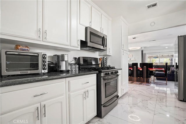 kitchen featuring marble finish floor, a toaster, stainless steel appliances, white cabinetry, and visible vents