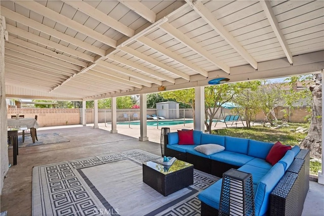 view of patio featuring an outdoor living space, a shed, a fenced backyard, an outbuilding, and a fenced in pool