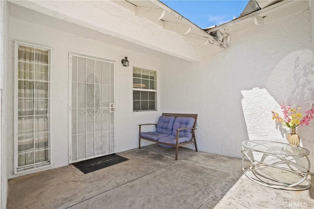 doorway to property with a patio and stucco siding