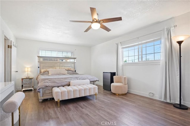 bedroom with baseboards, wood finished floors, ceiling fan, and multiple windows