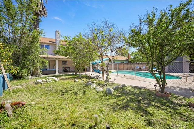 view of pool featuring a patio area, a fenced in pool, fence, and a lawn
