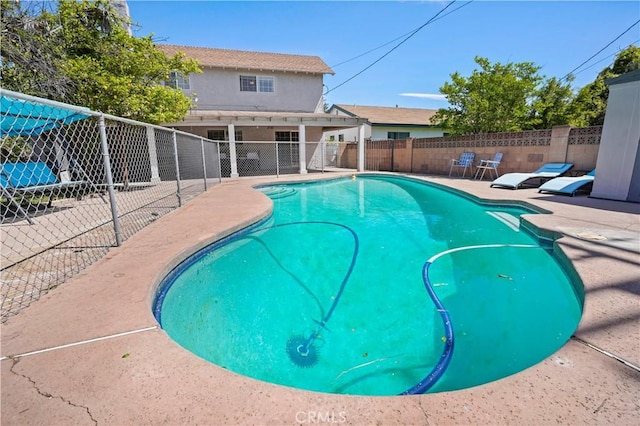 view of swimming pool with fence, a fenced in pool, and a patio