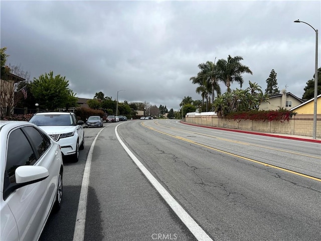 1111 S Coast Dr Unit 18, Costa Mesa, CA 92626 - view of asphalt road featuring street lights, curbs, and sidewalks