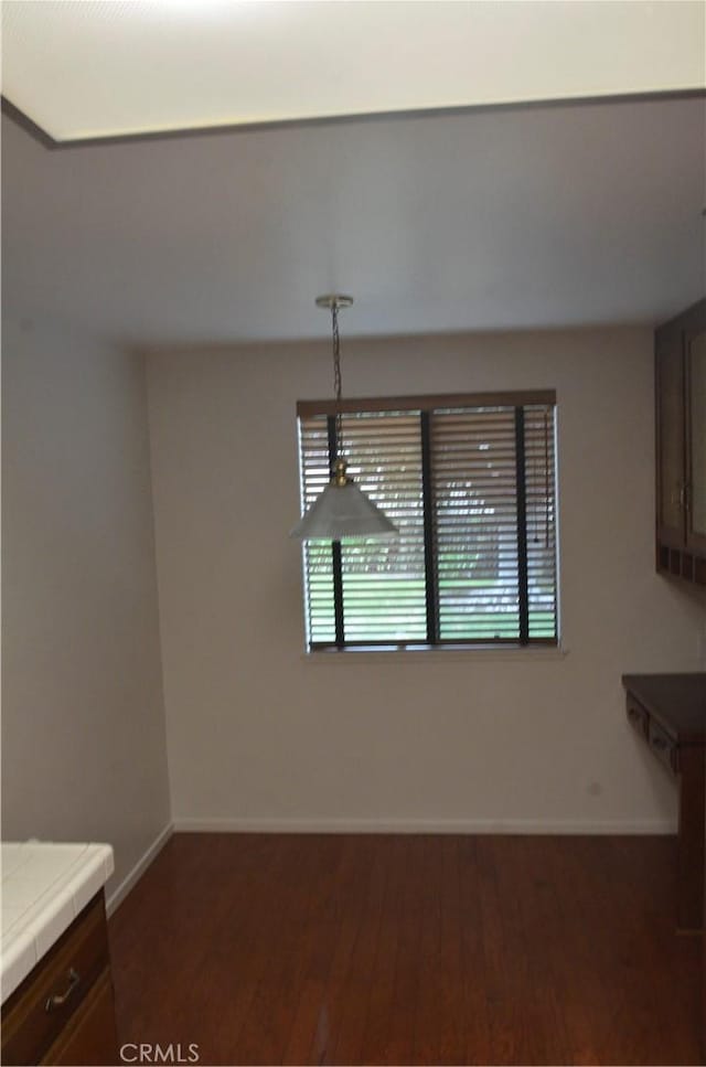 1111 S Coast Dr Unit 18, Costa Mesa, CA 92626 - unfurnished dining area featuring wood finished floors and baseboards