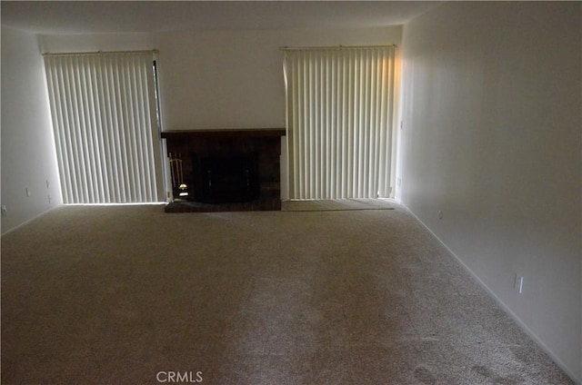 1111 S Coast Dr Unit 18, Costa Mesa, CA 92626 - unfurnished living room featuring carpet floors, a fireplace, and baseboards
