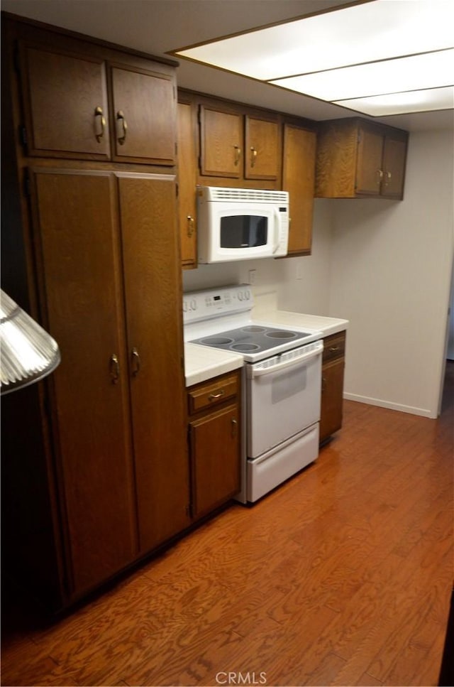 1111 S Coast Dr Unit 18, Costa Mesa, CA 92626 - kitchen featuring white appliances, wood finished floors, and light countertops