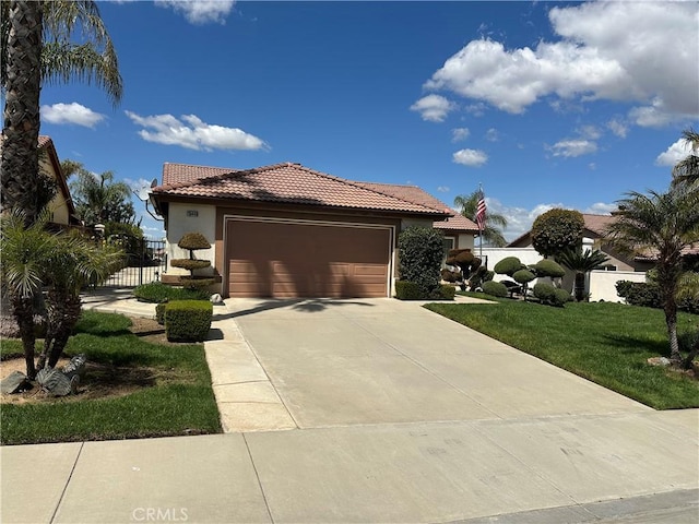 view of front of home with stucco siding, a garage, a tile roof, a front lawn, and concrete driveway