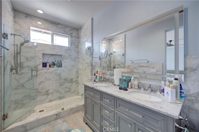 bathroom with double vanity, marble finish floor, a sink, and a marble finish shower
