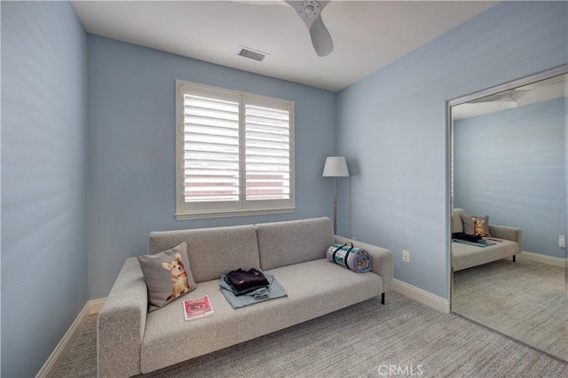 carpeted living room featuring visible vents, ceiling fan, and baseboards