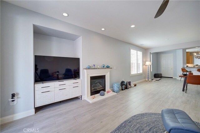 living room with baseboards, recessed lighting, and light wood-style floors
