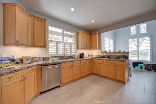 kitchen with dark stone counters, a peninsula, recessed lighting, dishwasher, and a sink