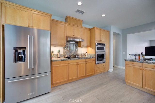 kitchen with under cabinet range hood, light brown cabinets, visible vents, and stainless steel appliances