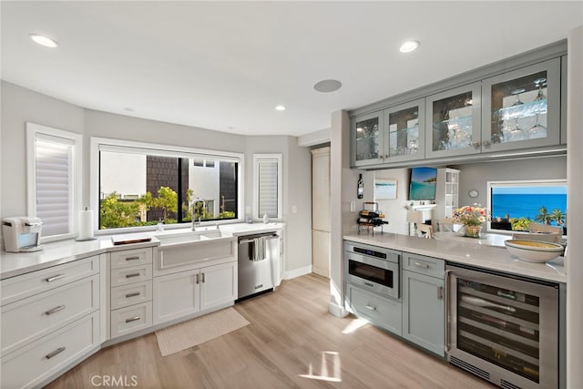 1001 Buena Vis Unit 2, San Clemente, CA 92672 - bar featuring beverage cooler, a sink, light wood-type flooring, appliances with stainless steel finishes, and recessed lighting