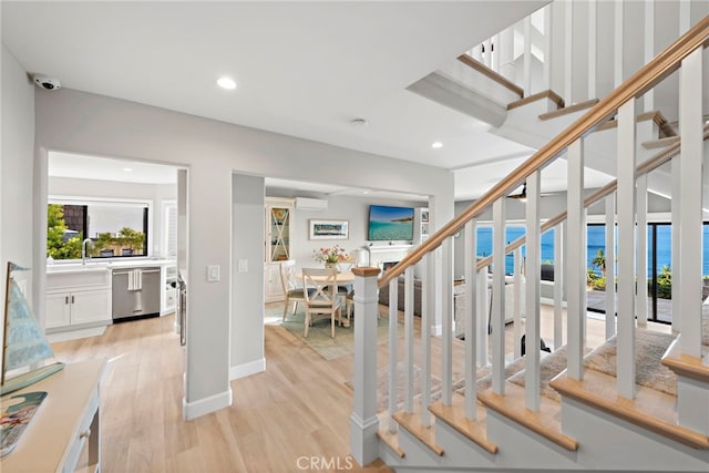 1001 Buena Vis Unit 2, San Clemente, CA 92672 - stairway featuring wood finished floors, baseboards, a wall mounted AC, and recessed lighting