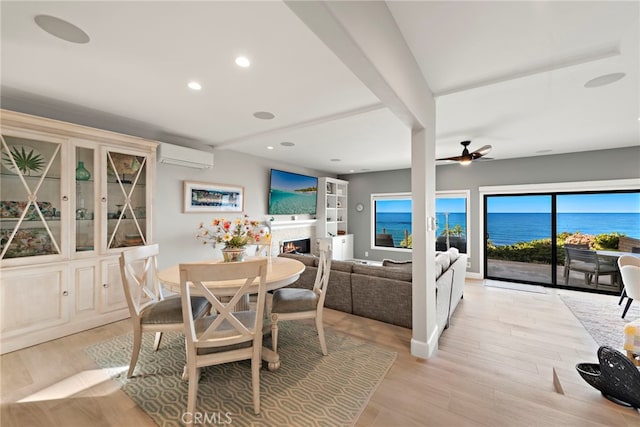 1001 Buena Vis Unit 2, San Clemente, CA 92672 - dining room with a ceiling fan, a wall mounted air conditioner, recessed lighting, light wood finished floors, and a lit fireplace