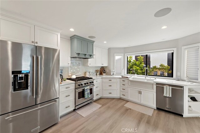 1001 Buena Vis Unit 2, San Clemente, CA 92672 - kitchen with light wood-style flooring, a sink, white cabinetry, high end appliances, and light countertops