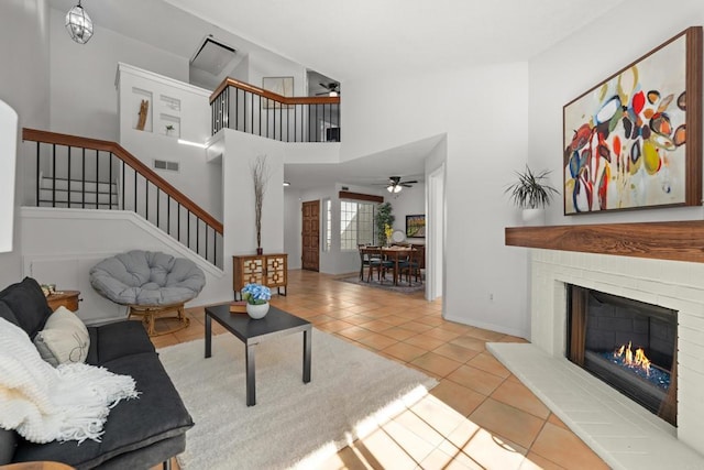1579 Apache Dr Unit E, Chula Vista, CA 91910 - tiled living area featuring stairs, a ceiling fan, a brick fireplace, and a towering ceiling