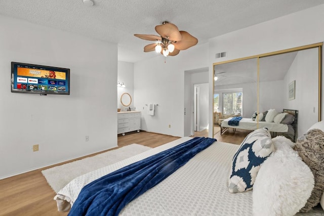1579 Apache Dr Unit E, Chula Vista, CA 91910 - bedroom featuring wood finished floors, ensuite bath, a closet, a textured ceiling, and ceiling fan